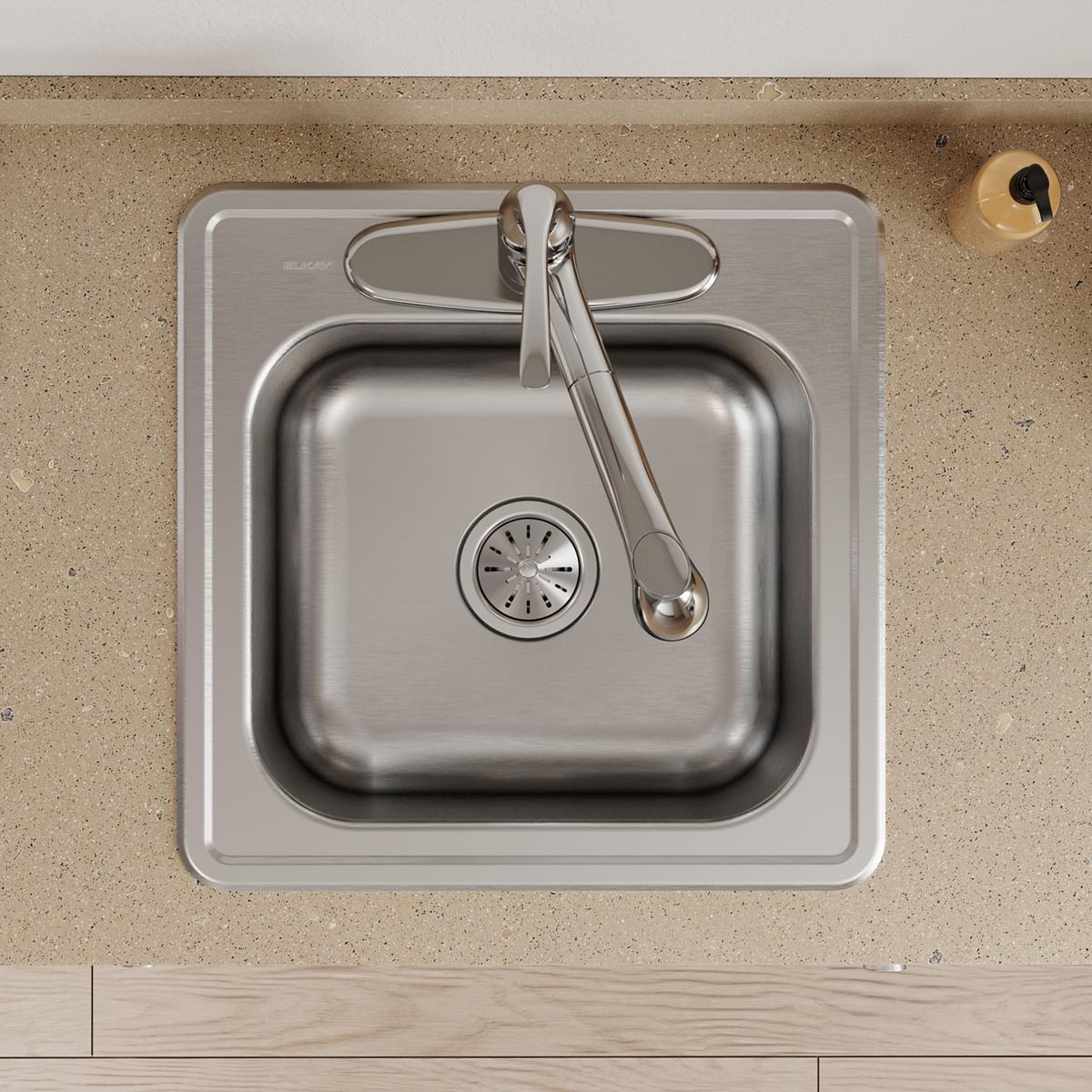 Stainless steel drop-in laundry sink with single bowl, drain, and faucet installed in countertop.