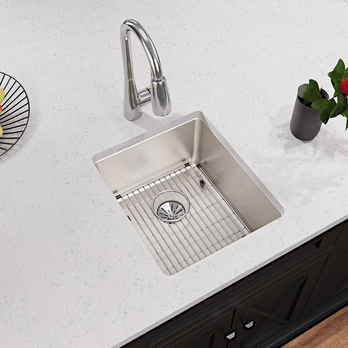 Stainless steel bottom grid with vertical slat pattern for kitchen sink basin.