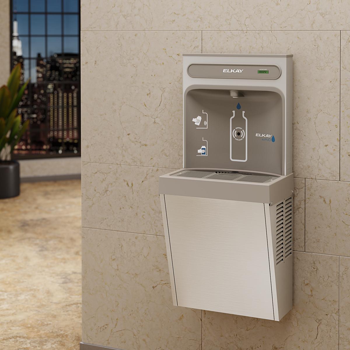 Stainless steel wall-mounted water bottle filling station with refrigeration unit and gray front panel installed on beige til