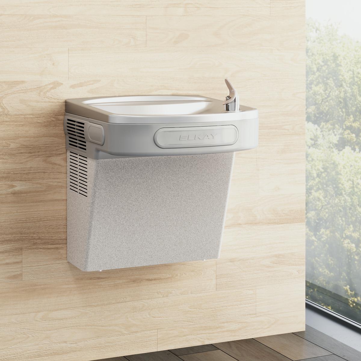 Light gray granite wall-mounted water cooler with curved basin and chrome faucet on wooden wall.
