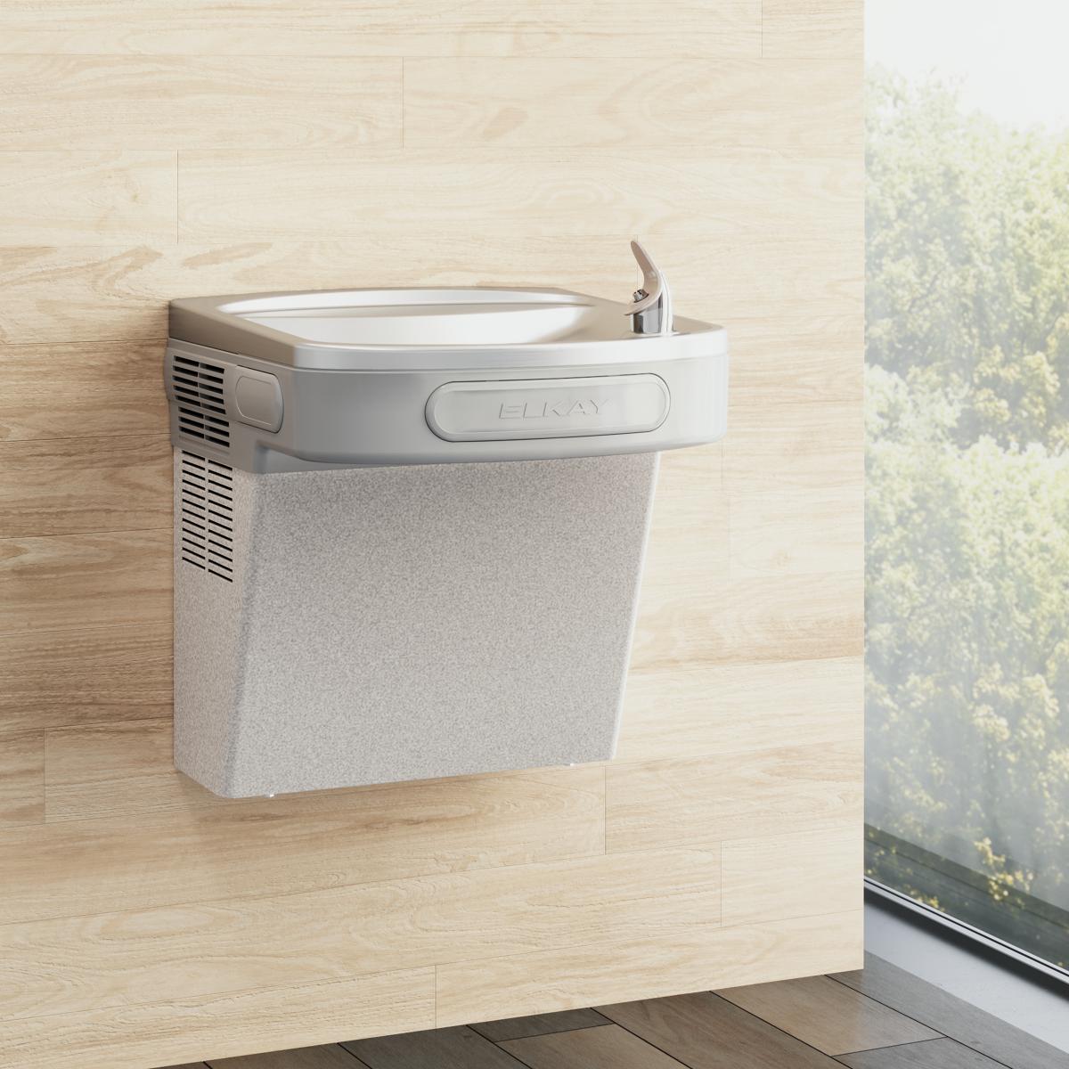 Light gray granite wall-mounted water cooler with curved basin and chrome faucet installed on light wood wall.