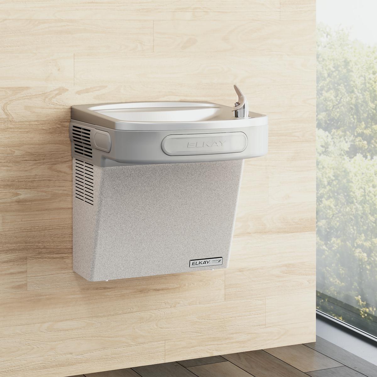 Light gray granite wall-mounted water cooler with curved basin and single lever spout installed on wood-look wall.