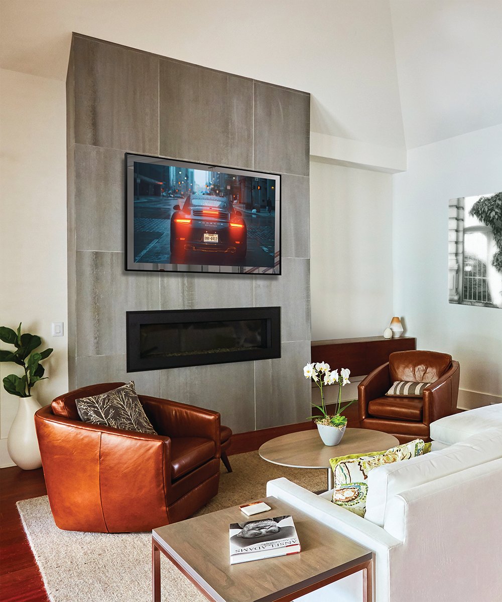 Black-framed TV mounted on gray tile wall above electric fireplace in living room.