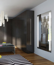 Tall lighted mirror with black frame mounted on white wall, LED strips along left and right edges illuminating the reflective