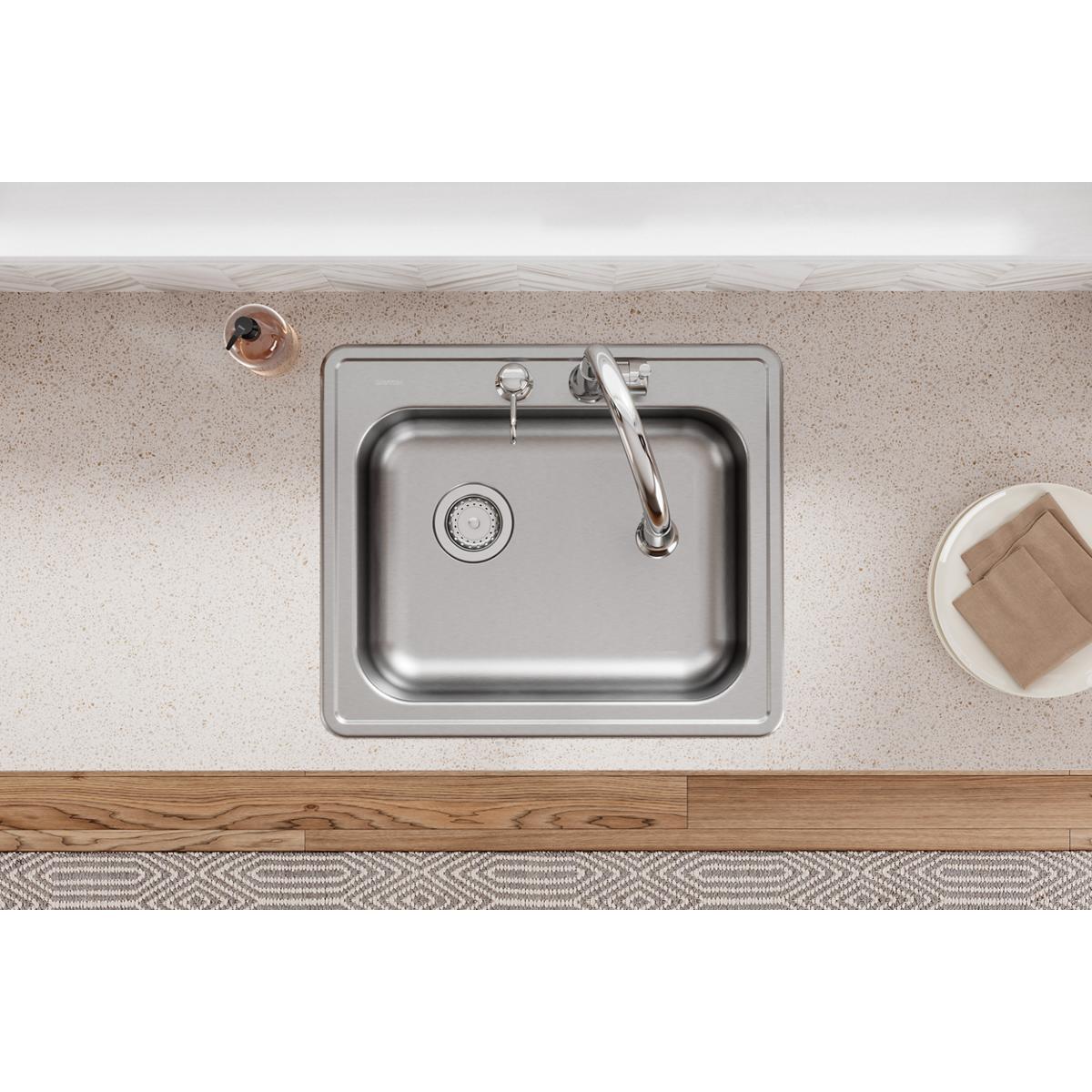 Stainless steel single bowl drop-in sink with two faucet holes and left drain installed in beige countertop.