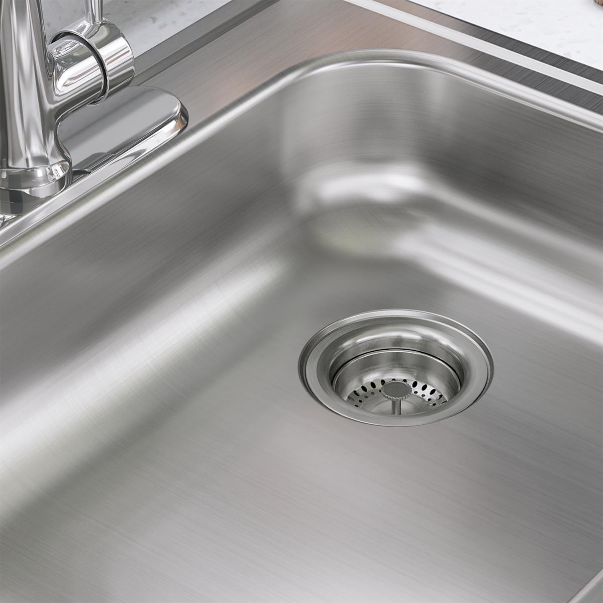 Stainless steel single bowl drop-in sink with drain strainer and faucet holes visible on brushed metal surface.