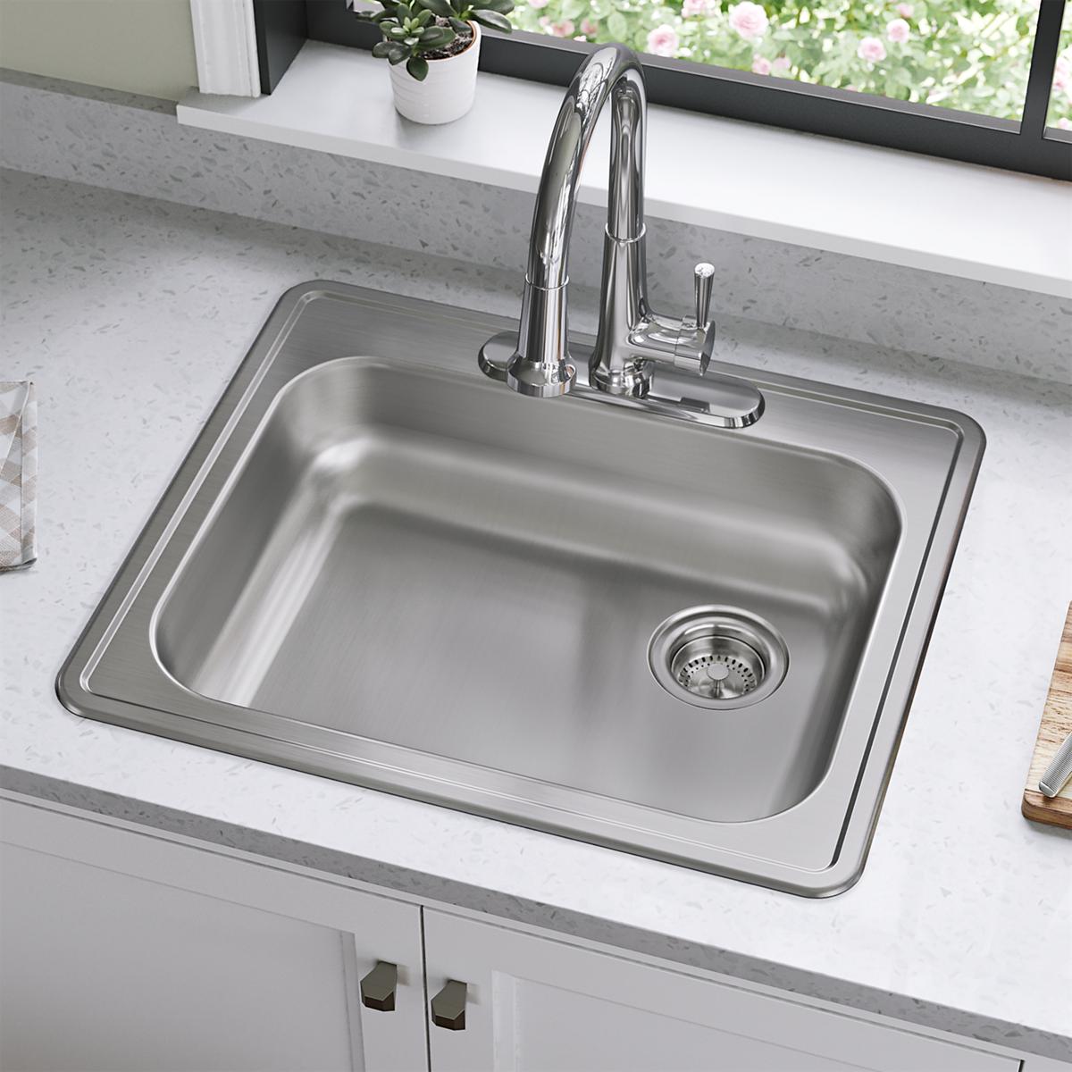Stainless steel drop-in sink with single bowl, right drain, and chrome faucet installed in white countertop.