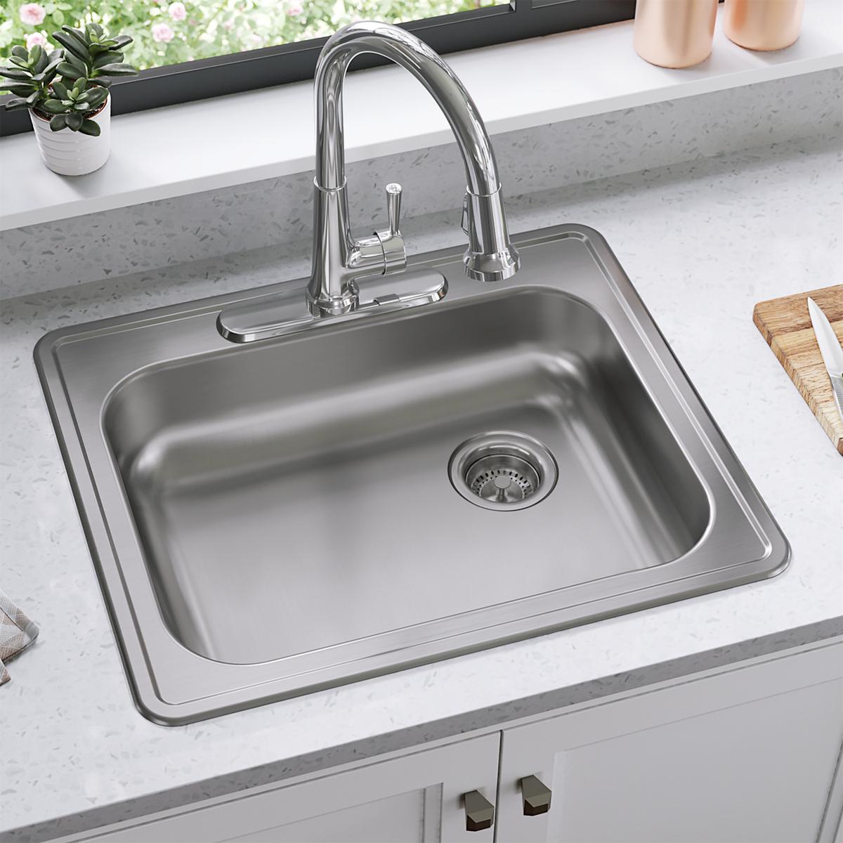 Stainless steel drop-in sink with single bowl, drain strainer, and chrome pull-down faucet installed in countertop.