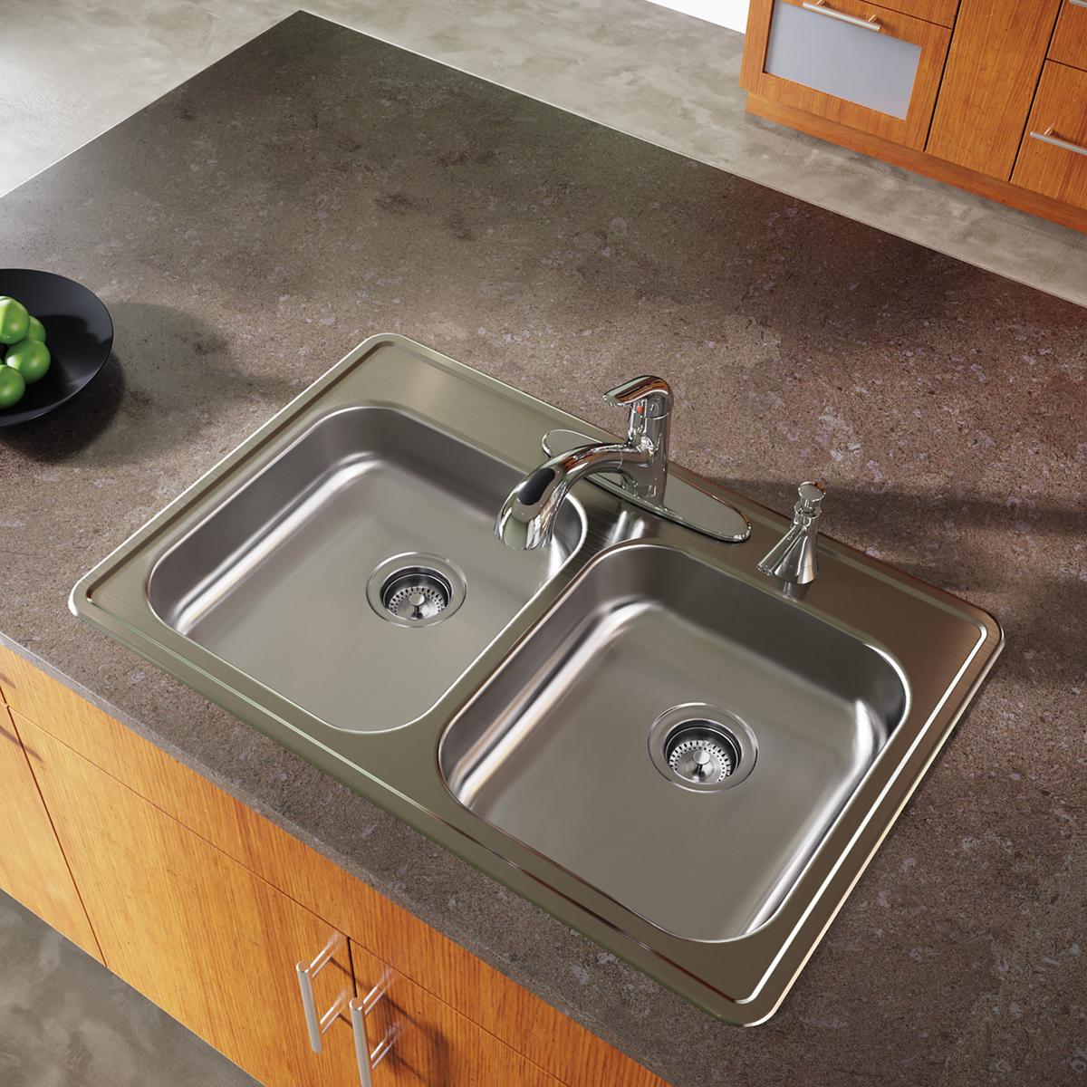 Stainless steel double bowl drop-in kitchen sink with two faucets and drain strainers installed in countertop.