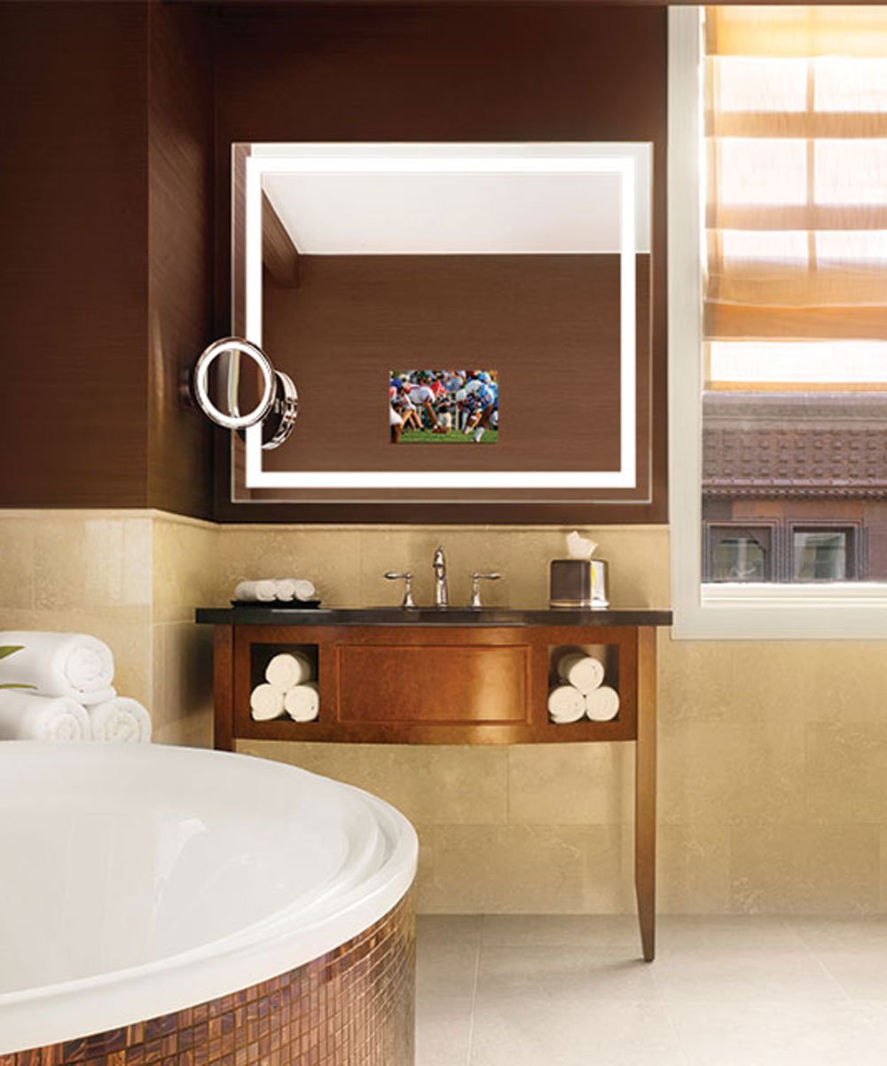 Bathroom mirror with white LED frame border displaying small TV screen in center, mounted above vanity.