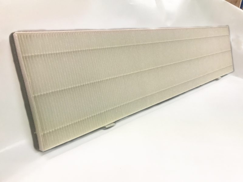 Rectangular pleated air filter with white accordion-style pleats and gray frame, shown at an angle on white surface.