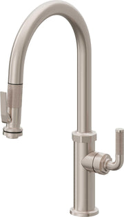 Burnished brass kitchen faucet with high arc spout, pull-down sprayer head, and side spray handle.