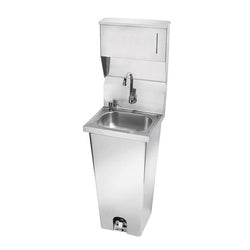 Stainless steel pedestal hand sink with foot valve, faucet, and integrated soap and towel dispensers.