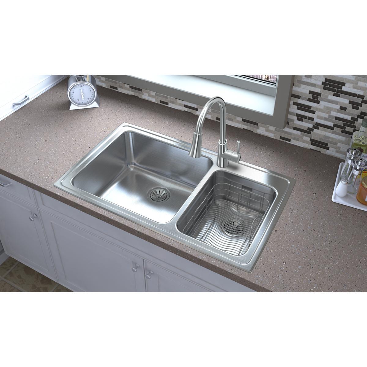 Stainless steel drop-in sink with two bowls, larger left basin and smaller right basin with ribbed bottom, installed in count