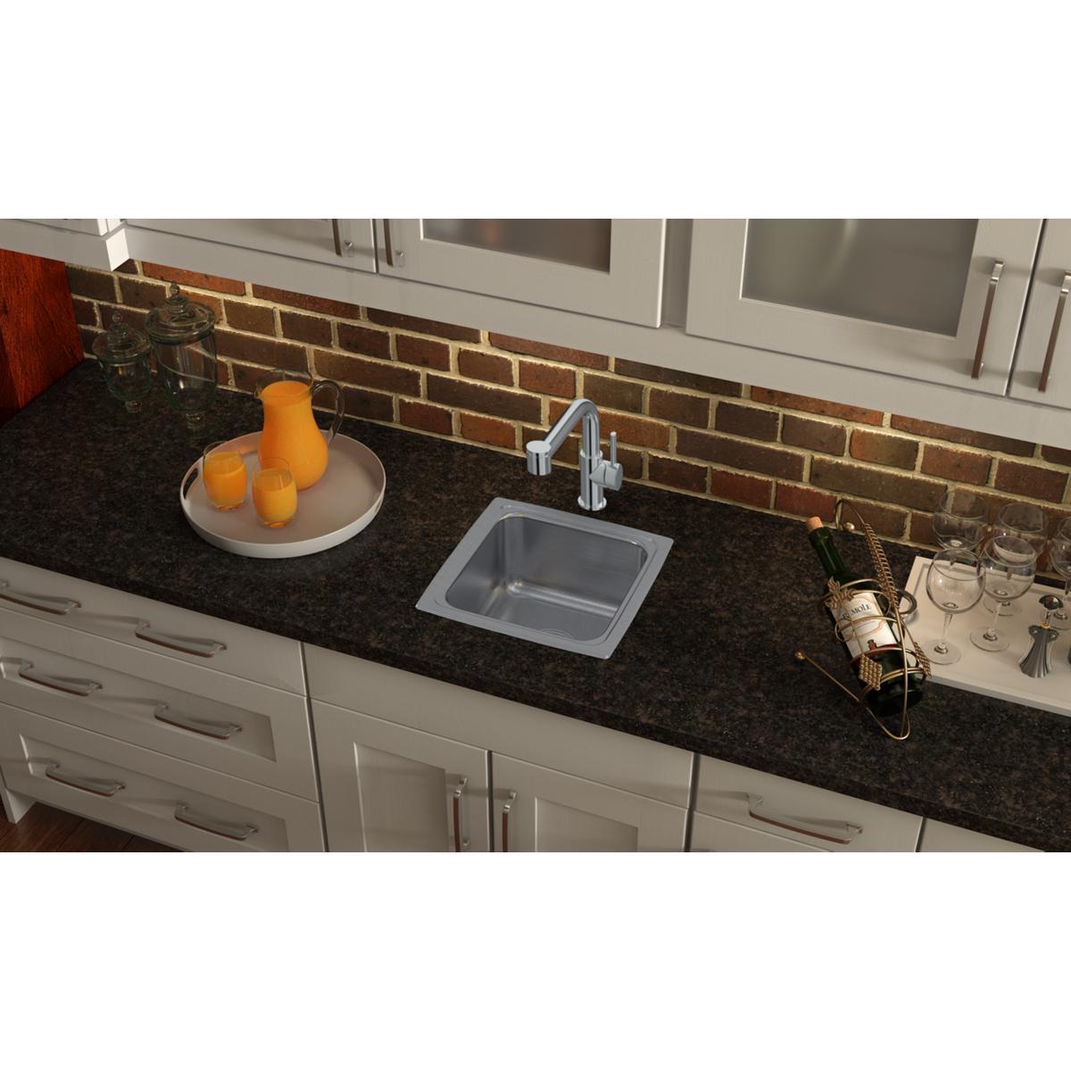 Stainless steel square drop-in bar sink installed in dark countertop with chrome faucet and white cabinetry below.