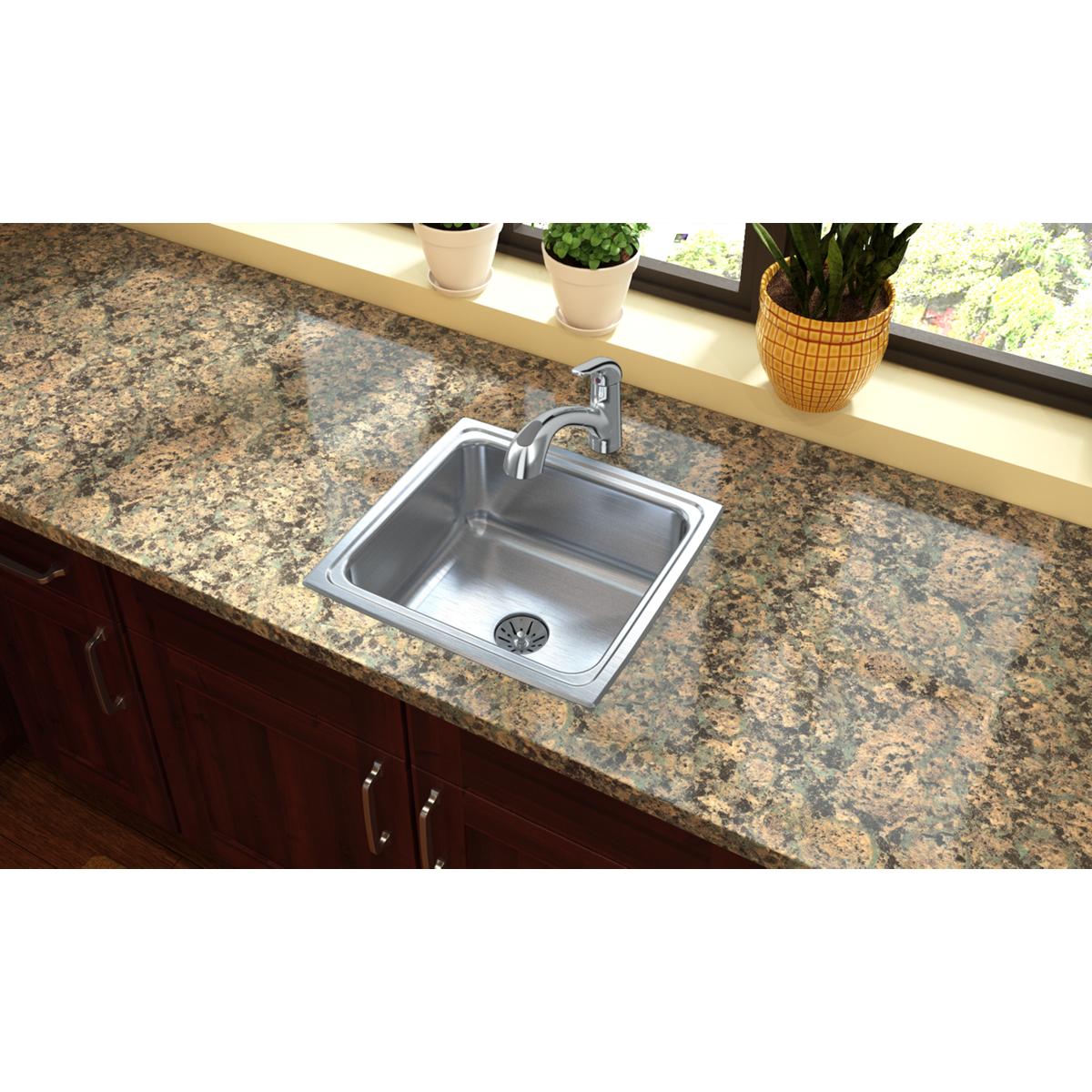 Stainless steel single bowl drop-in sink with faucet installed in granite countertop.