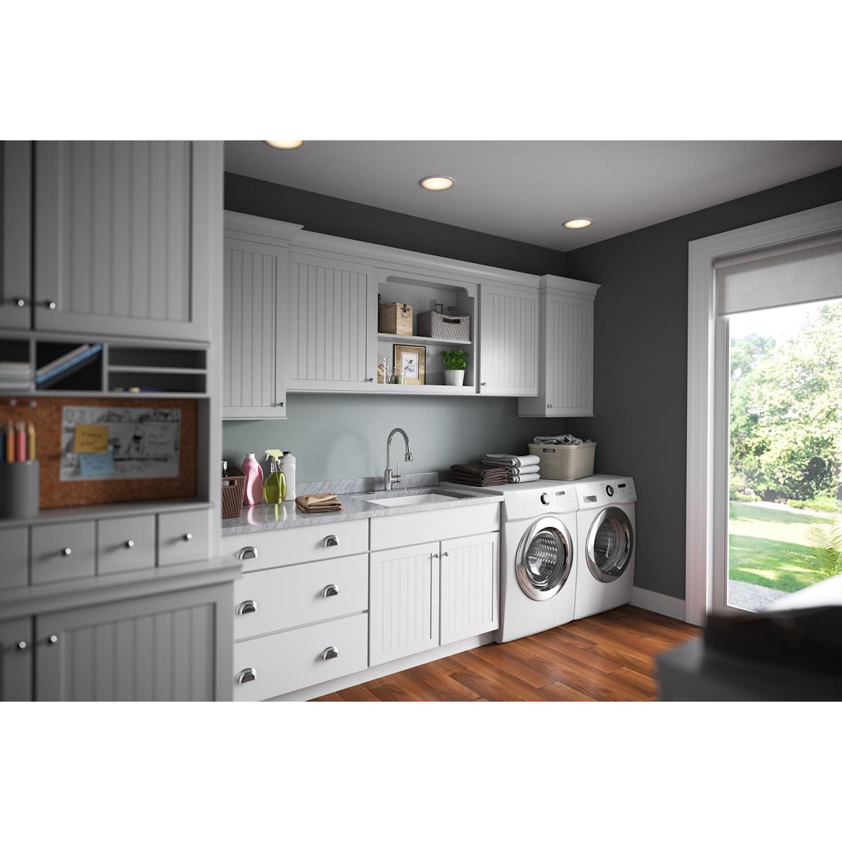 Chrome laundry faucet with flexible spout and single forward lever handle mounted in utility sink.