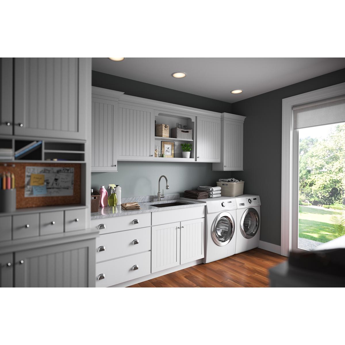 Stainless steel laundry faucet with single lever handle and flexible spout installed above utility sink in laundry room.