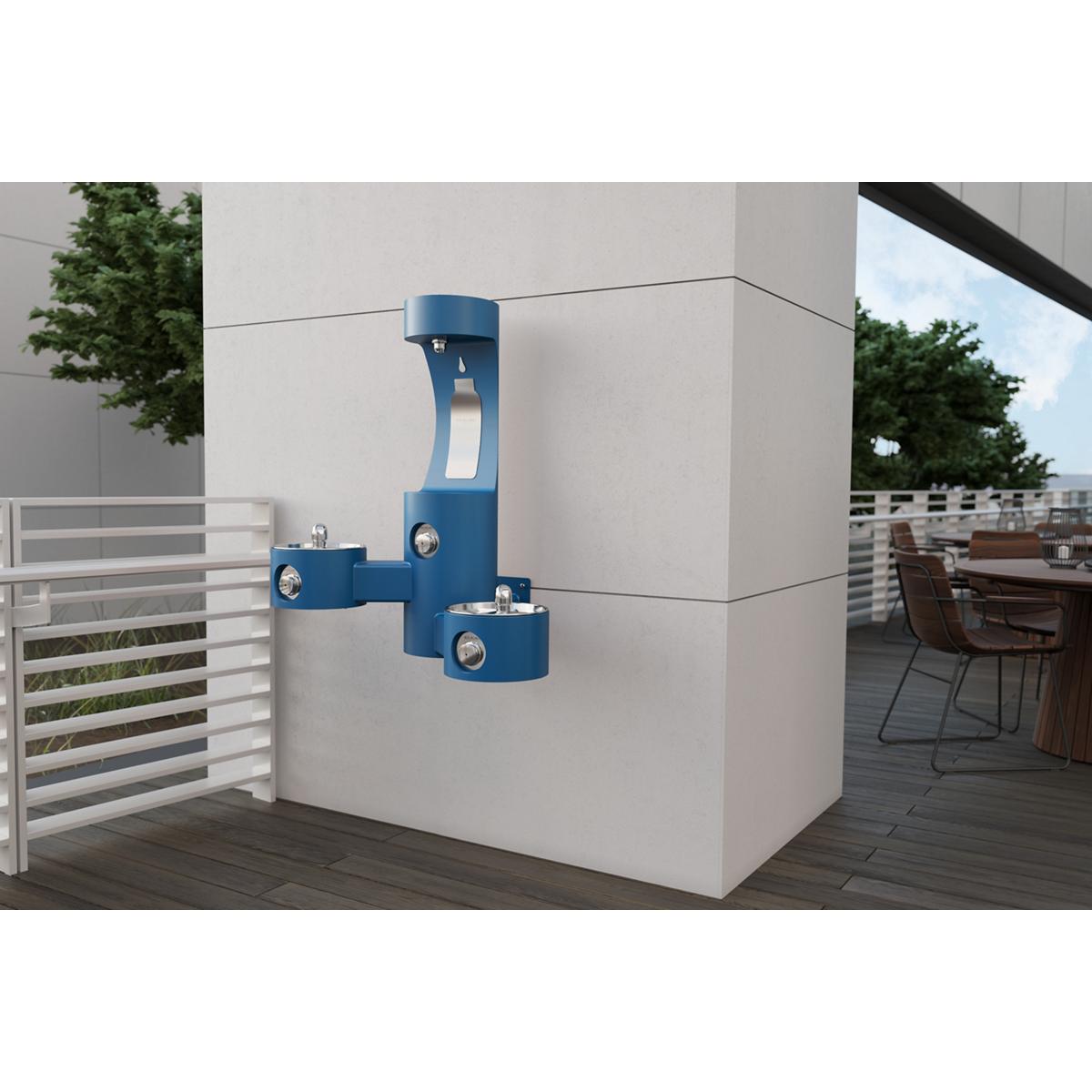 Blue wall-mounted outdoor water fountain and bottle filling station with two water dispensing levels mounted on concrete wall
