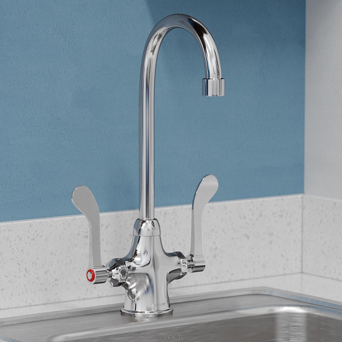 Chrome kitchen faucet with curved gooseneck spout and two wristblade handles on white countertop.