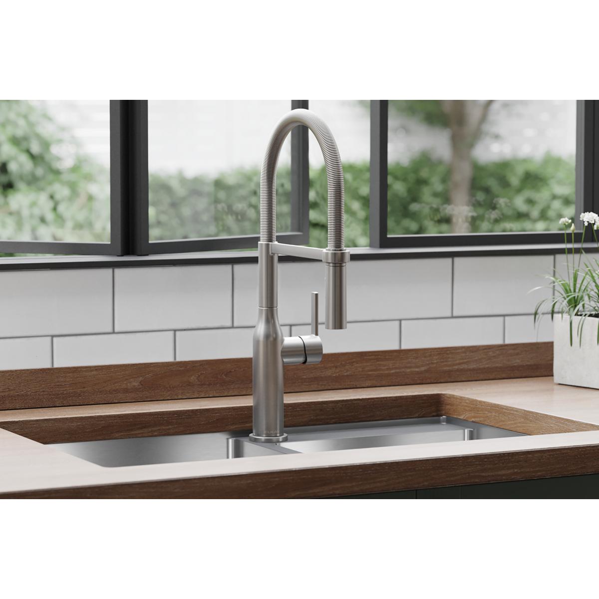 Lustrous steel single-hole kitchen faucet with semi-professional curved spout and forward lever handle installed in sink.