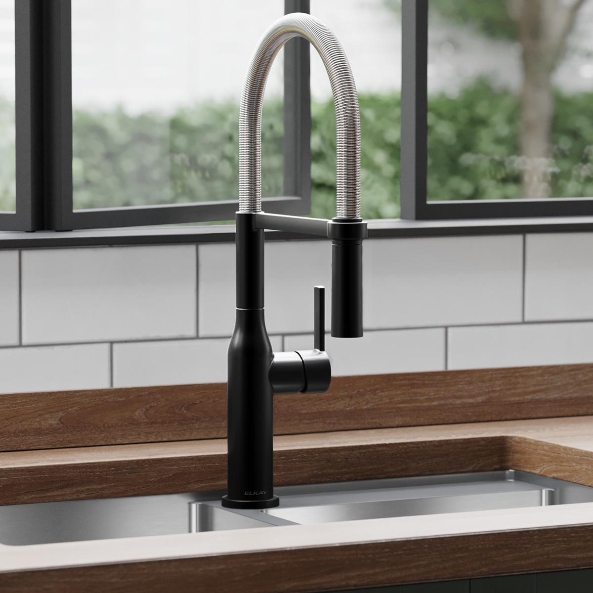 Matte black and chrome single-hole kitchen faucet with flexible stainless steel spout and forward lever handle installed in s