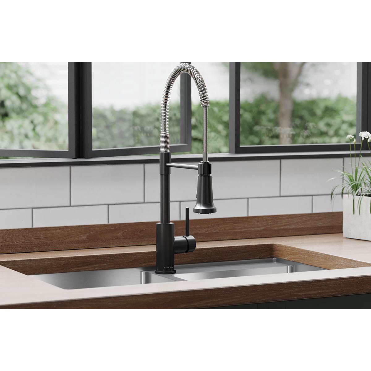 Black stainless steel and chrome single-hole kitchen faucet with semi-professional coiled spout and lever handle mounted on s