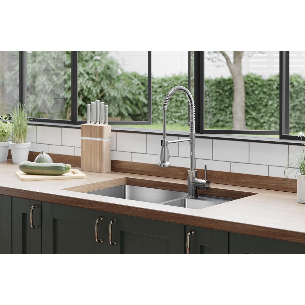 Chrome kitchen faucet with curved semi-professional spout and single lever handle mounted above stainless steel sink.