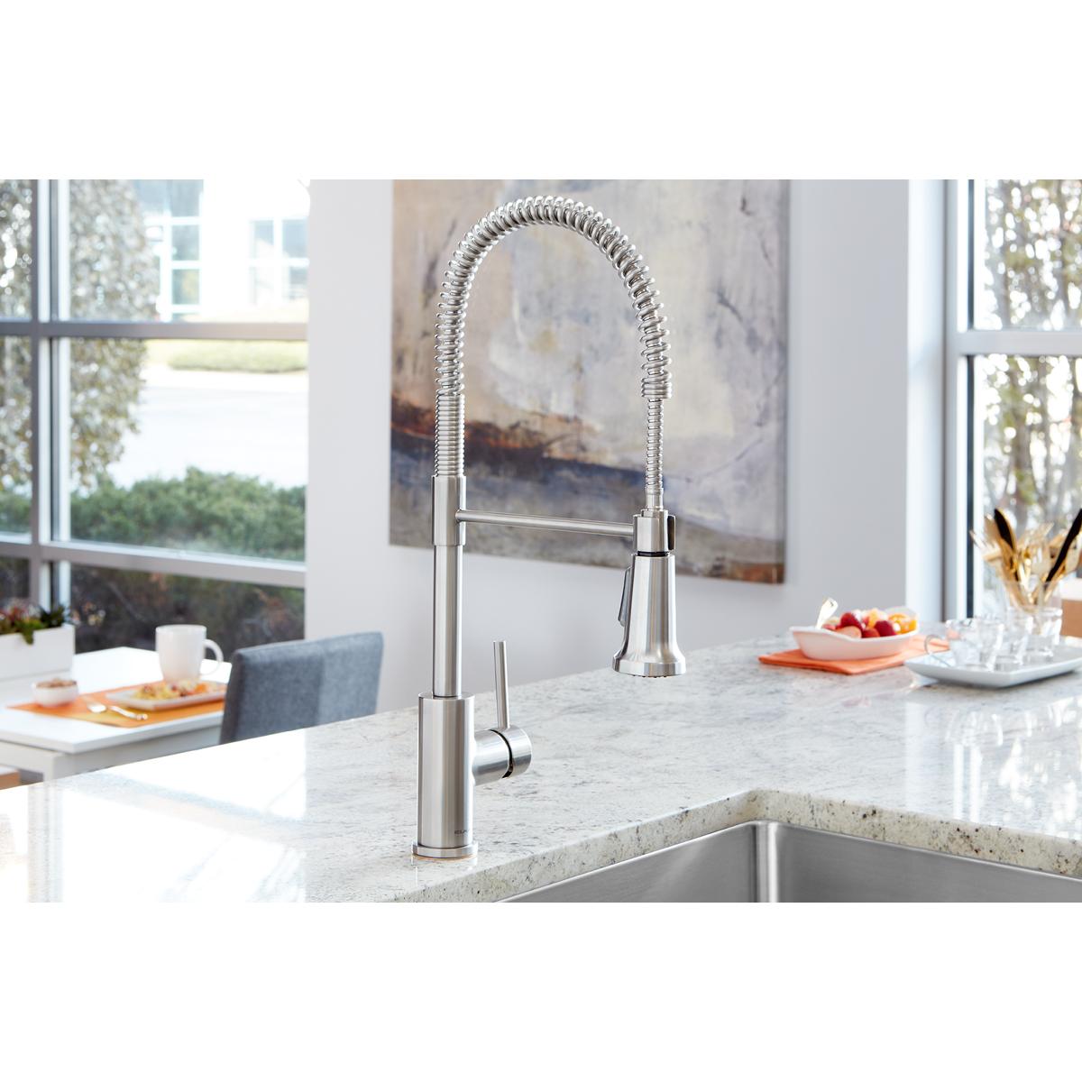 Lustrous steel kitchen faucet with flexible coiled spout and lever handle mounted on marble countertop.