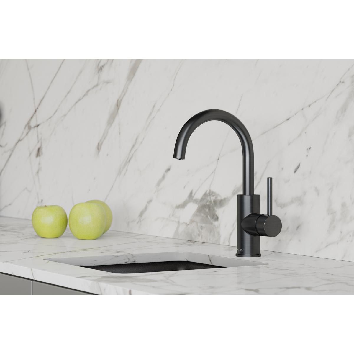 Black stainless steel bar faucet with curved spout and lever handle installed on marble countertop above sink.