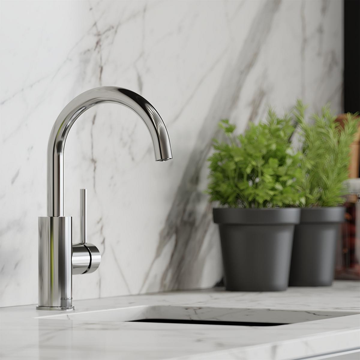 Chrome bar faucet with curved spout and lever handle on marble countertop.