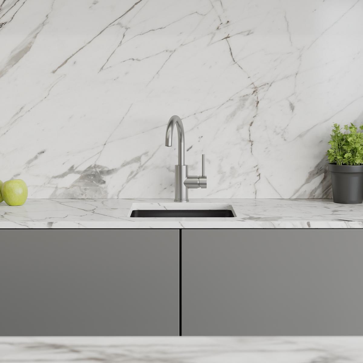 Lustrous steel bar faucet with single lever handle mounted above undermount sink on marble countertop.