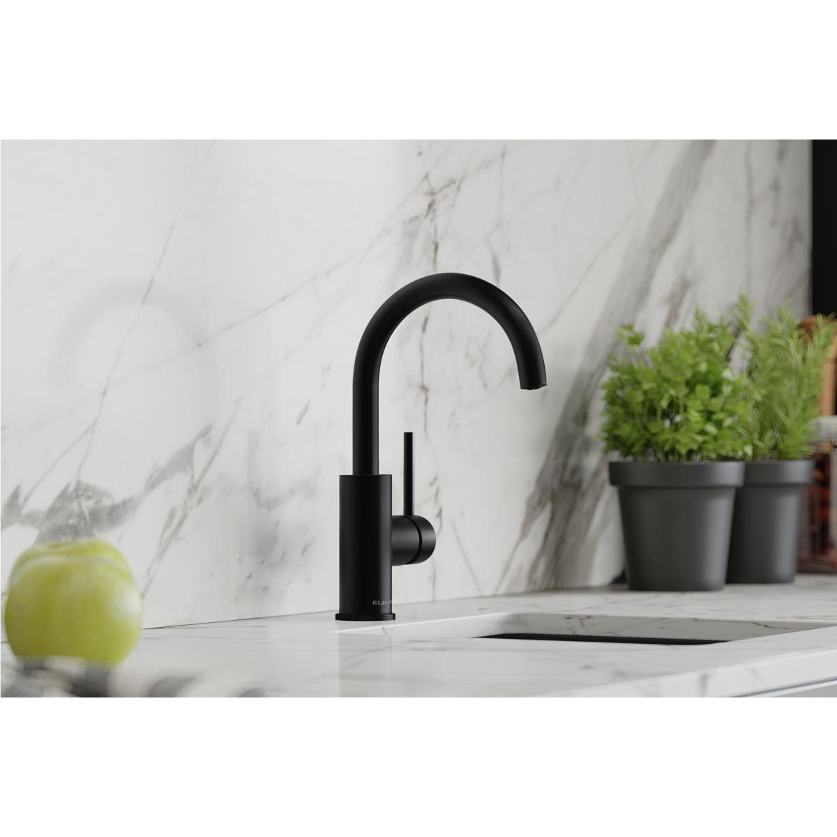 Matte black single-hole bar faucet with curved spout and lever handle on marble countertop.