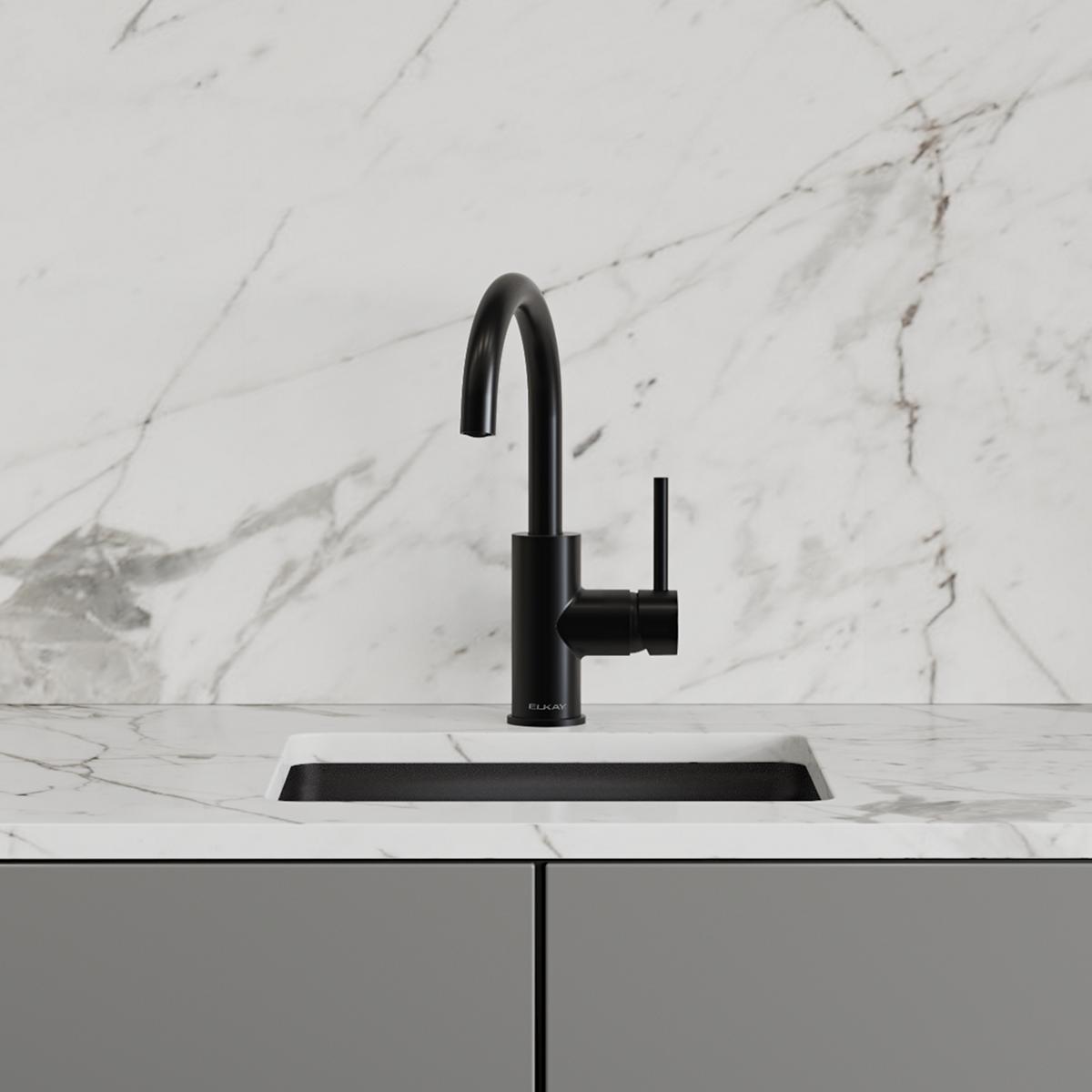 Matte black single-hole bar faucet with curved spout and lever handle mounted on marble countertop.