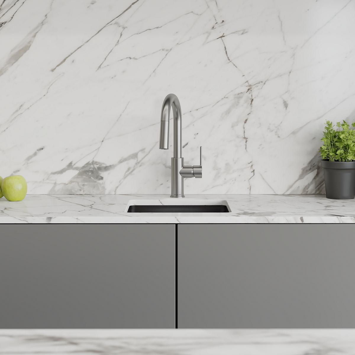 Lustrous steel single-hole bar faucet with pull-down spray and lever handle mounted on marble countertop with sink.