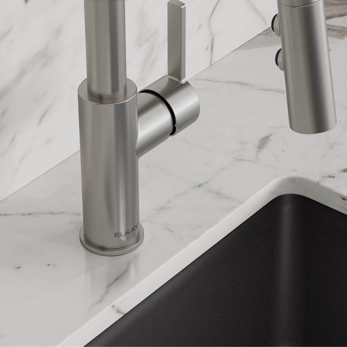 Lustrous steel bar faucet with pull-down spray mounted on marble countertop next to black sink.