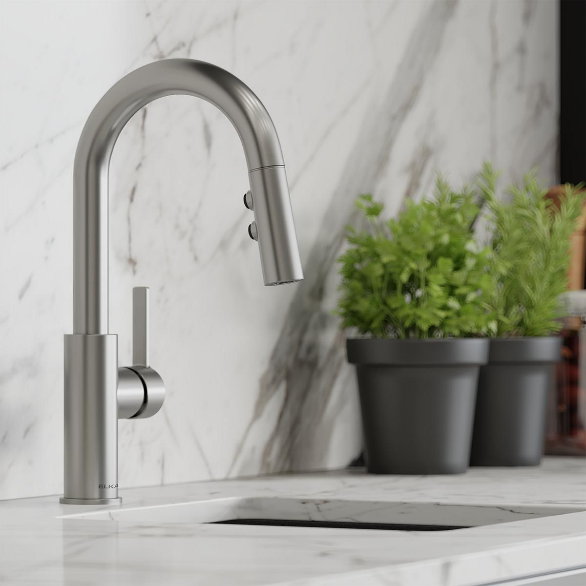Brushed stainless steel bar faucet with curved spout, pull-down spray head, and lever handle mounted on marble countertop.