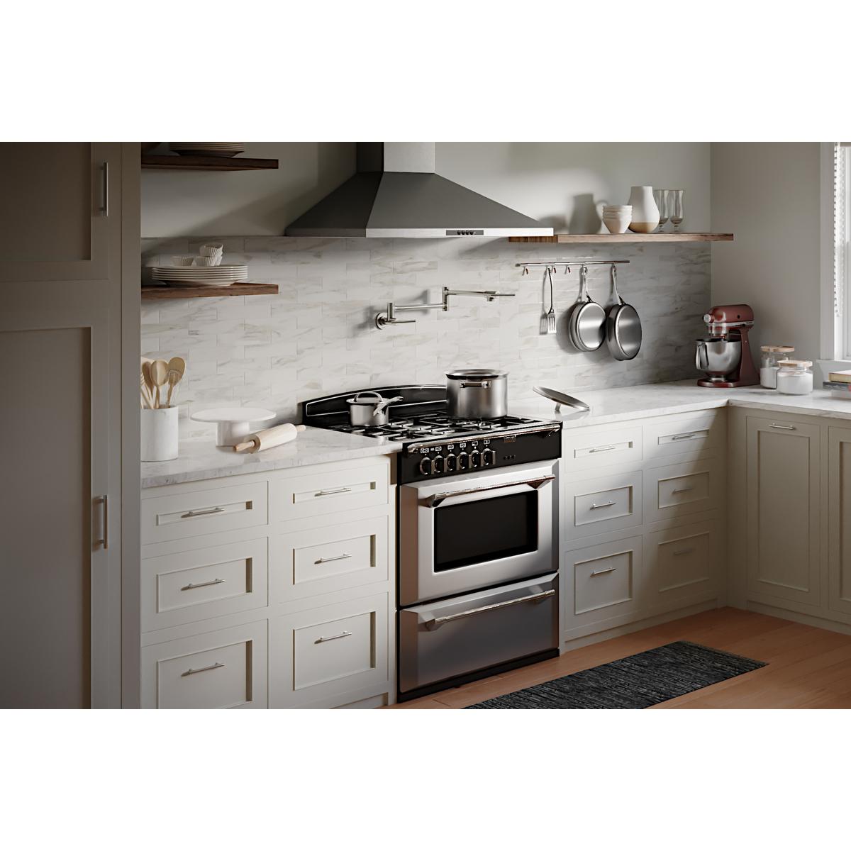 Chrome wall-mounted pot filler faucet with lever handles installed above kitchen countertop near stovetop.