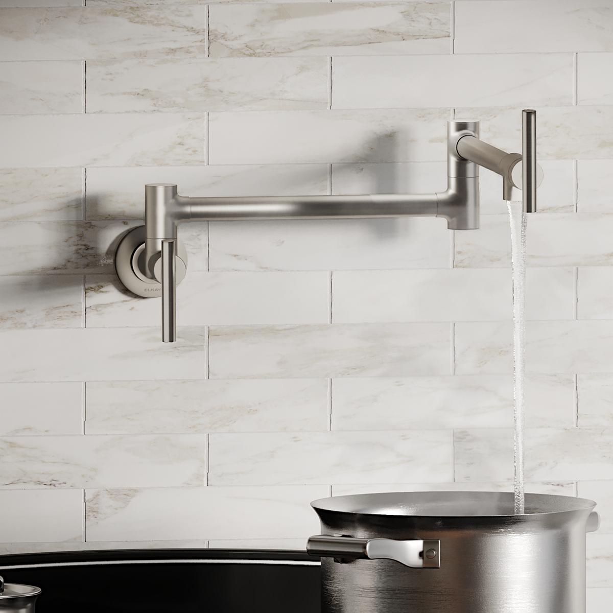 Lustrous steel wall-mounted pot filler faucet with lever handle and articulating arm filling a large pot.