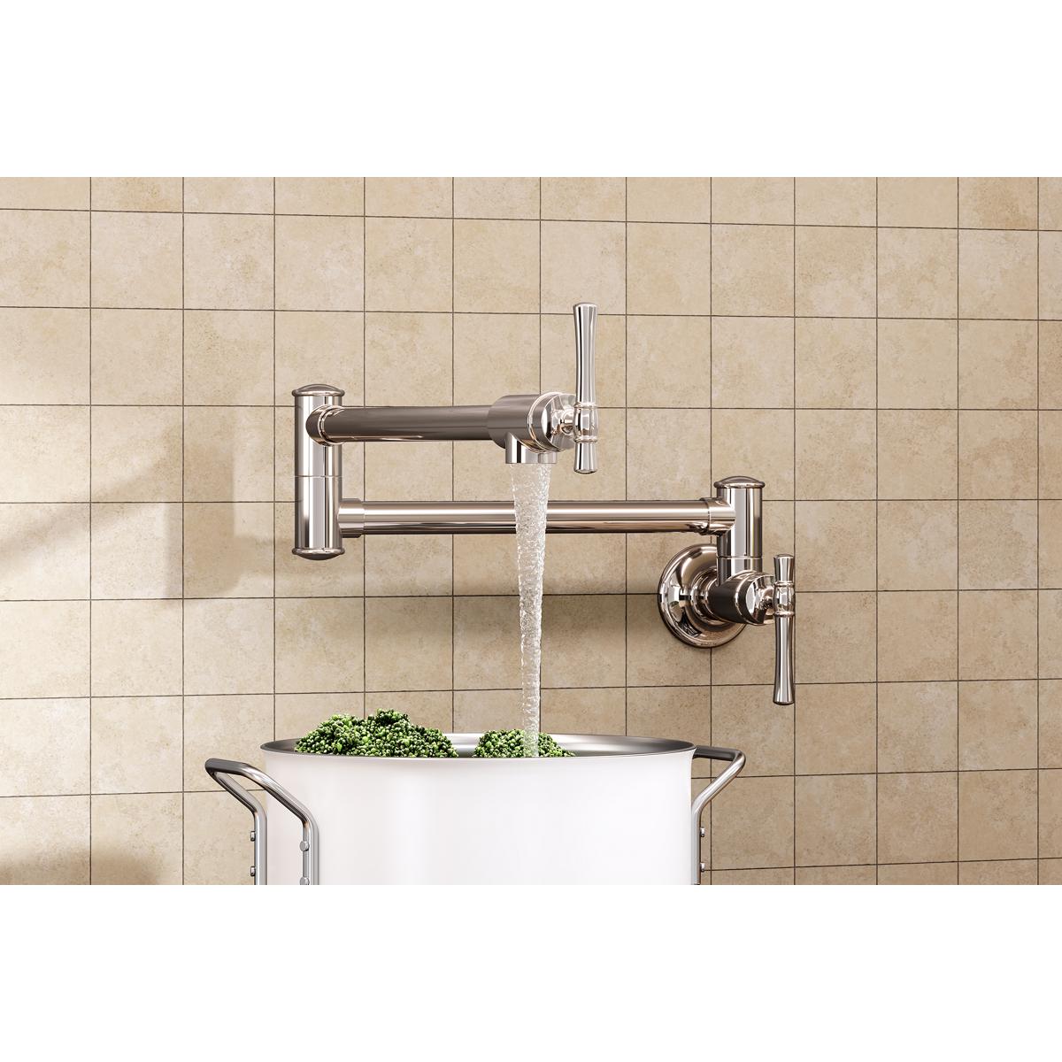 Polished nickel wall-mounted pot filler faucet with lever handles dispensing water into a white pot against beige tile.