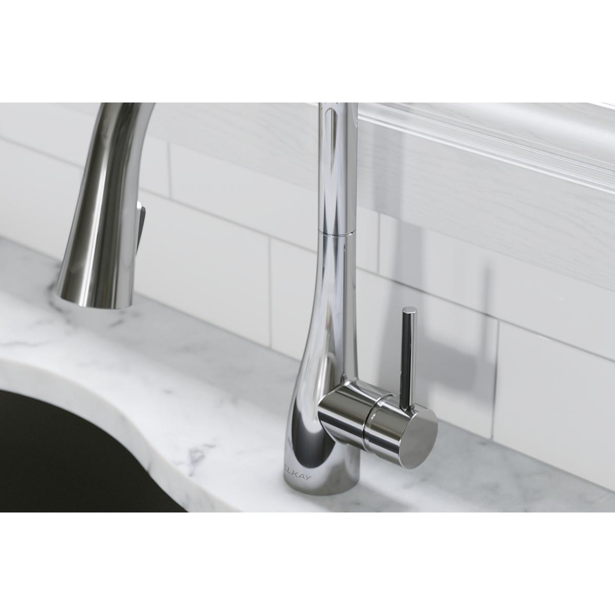Chrome kitchen faucet with curved spout and pull-down spray mounted on white marble sink countertop.