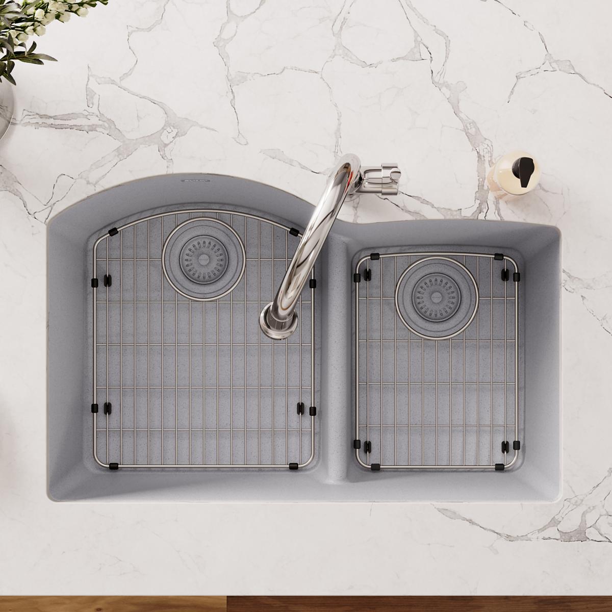 Stainless steel sink grid with rectangular pattern and rubber feet, shown installed in double basin sink.
