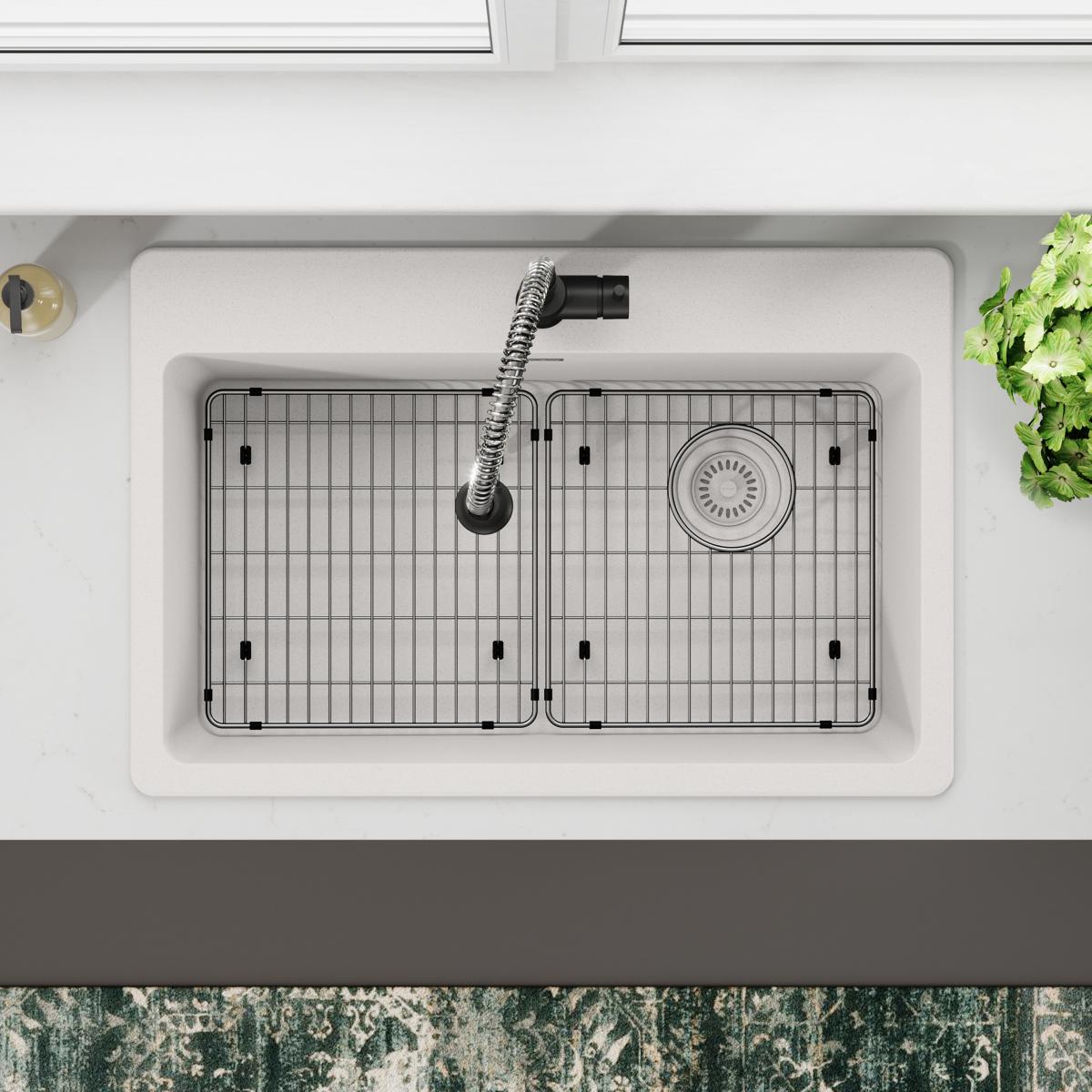 Stainless steel sink grid with vertical bar pattern and mounting posts, positioned in double basin sink.