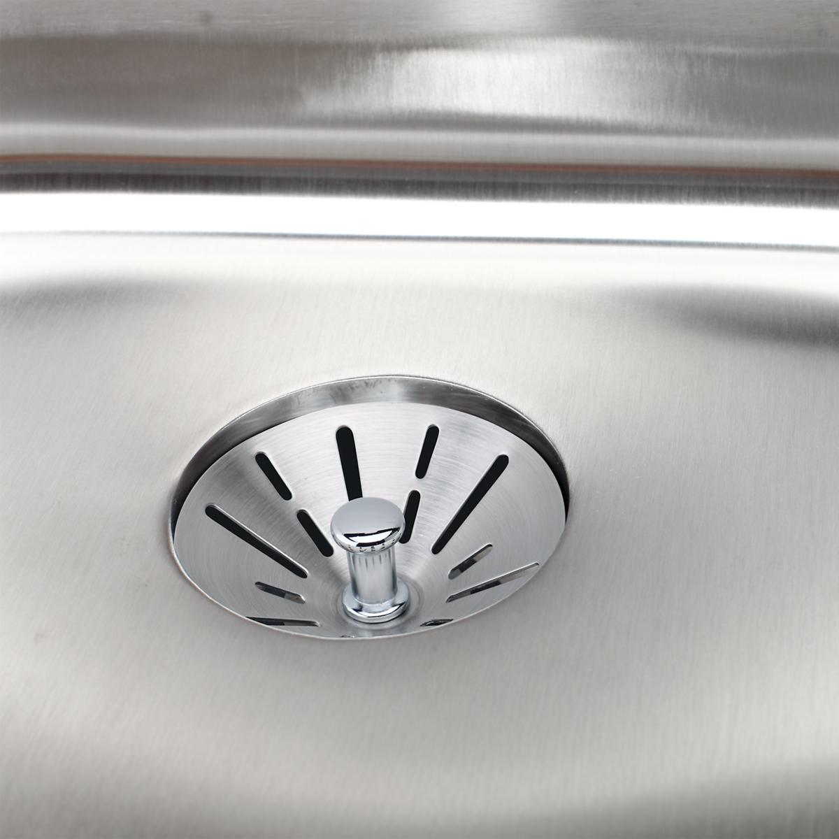 Stainless steel sink drain fitting with circular strainer basket and central post, installed in sink basin.
