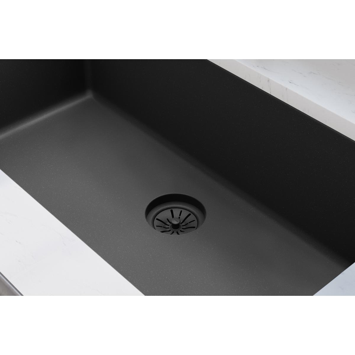 Charcoal polymer sink drain flange with basket strainer insert in black quartz sink basin.