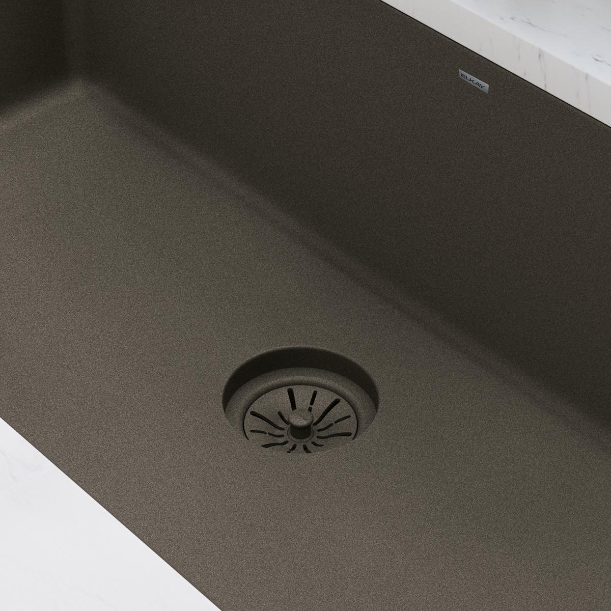 Chestnut polymer drain flange with radial pattern installed in quartz sink basin.