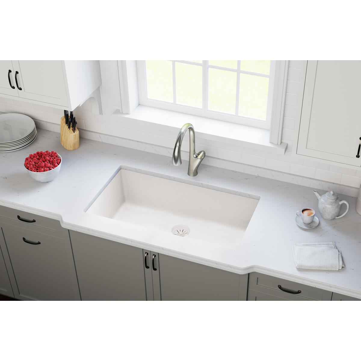 White quartz kitchen sink with integrated drain flange and basket strainer visible at bottom center.