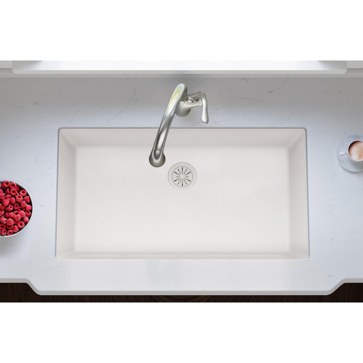 Ricotta-colored quartz sink with chrome faucet and circular drain strainer visible in center.