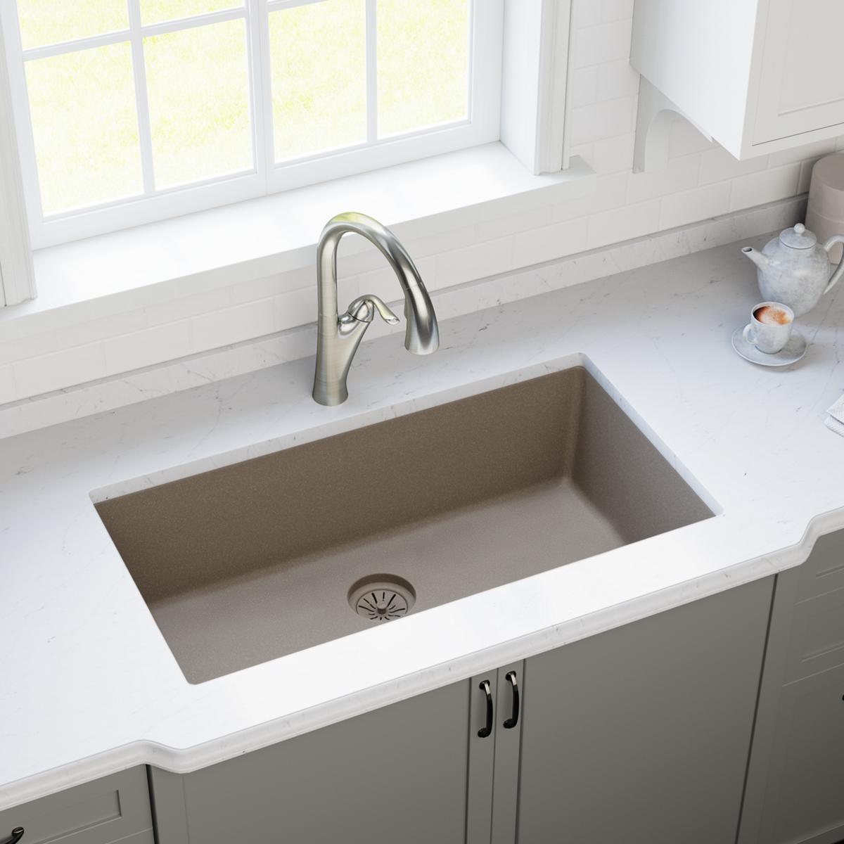 Silvermist gray quartz sink with disposer flange and basket strainer visible at bottom center of undermount basin.