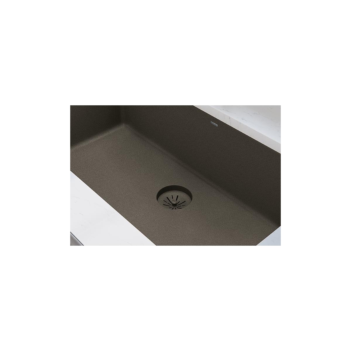 Chestnut quartz sink with black basket strainer and drain opening visible in basin.